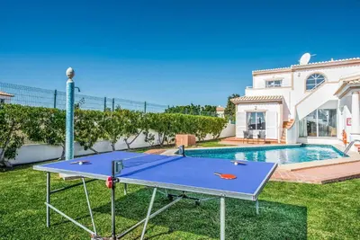 a ping pong table in the yard of a house at Villa Damara in Albufeira