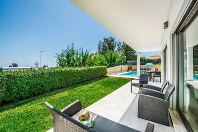 a patio with chairs and a swimming pool at Villa Sao Joao in Caliços
