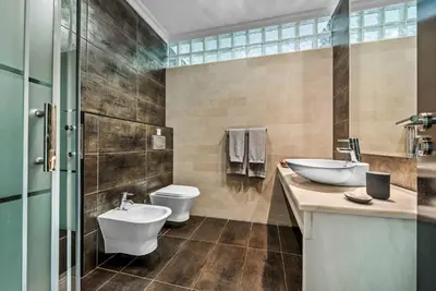 a bathroom with two sinks and a toilet and a tub at Villa Sao Joao in Caliços