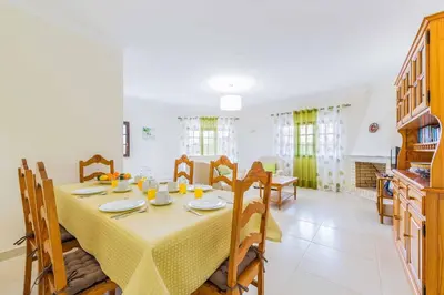 a dining room and kitchen with a table and chairs at Villa Ponderosa in Quarteira