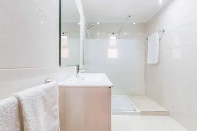 a white bathroom with a sink and a mirror at Villa Ponderosa in Quarteira