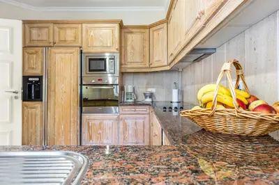 a kitchen with a basket of fruit on a counter at Encosta Do Lago Resort Club in Quinta do Lago