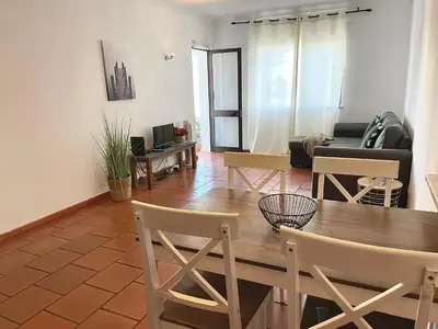 a living room with a wooden table and chairs at Apartamento bem localizado in Albufeira