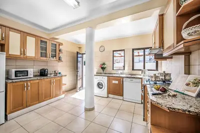 a large kitchen with wooden cabinets and white appliances at Villa Charlota in Albufeira