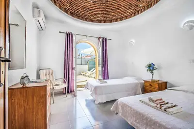 a hotel room with two beds and a mirror at Villa Arines in Albufeira