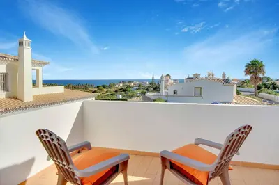 a balcony with two chairs and a view of the ocean at Villa Adele in Albufeira