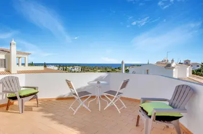 a patio with chairs and a table on a roof at Villa Adele in Albufeira