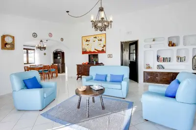 a living room with two blue chairs and a table at Villa Brigida in Albufeira