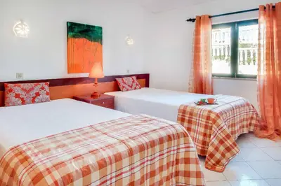 a bedroom with two beds and a window at Villa Brigida in Albufeira