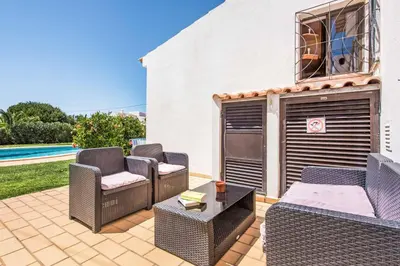 a patio with chairs and a table and a pool at Villa Severino in Albufeira