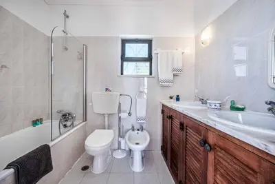 a bathroom with a toilet and a tub and a sink at Villa Severino in Albufeira