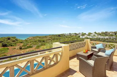 a balcony with chairs and a view of the ocean at Villa Coelha in Albufeira