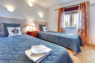 a bedroom with two beds and a window at Villa Coelha in Albufeira