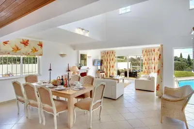 a dining room and living room with a table and chairs at Villa Ceylon in Albufeira