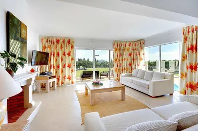 a living room with a white couch and a tv at Villa Ceylon in Albufeira