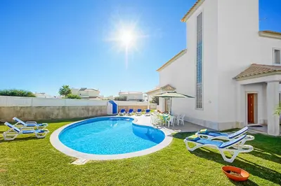 a backyard with a pool and chairs and a house at Casa Ferrero in Guia