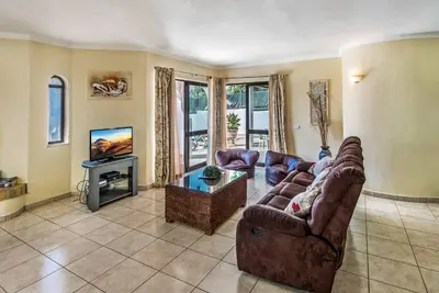 a living room with a couch and a tv at Villa Miramar in Albufeira