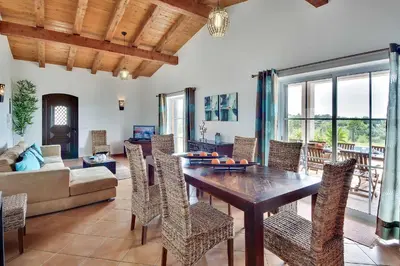 a living room with a wooden table and chairs at Villa Monte de Madrinha in Albufeira