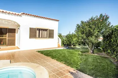 a house with a swimming pool next to a yard at Villa Lourenco in Albufeira