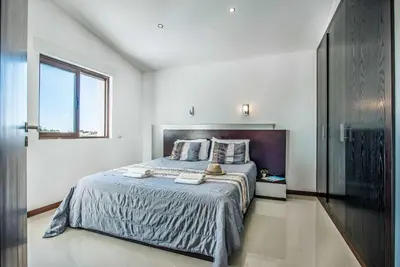 a bedroom with a bed and a window at Casa dos Amigos in Albufeira