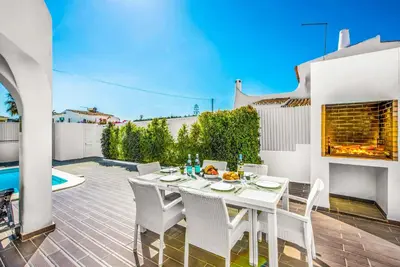 a white dining table and chairs on a patio at Casa dos Amigos in Albufeira