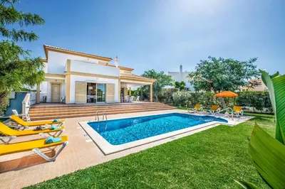a villa with a swimming pool in front of a house at Villa Altair in Albufeira