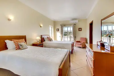 a bedroom with two beds and a living room at Villa Sunny in Albufeira