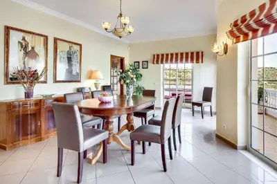 a dining room with a wooden table and chairs at Villa Sunny in Albufeira