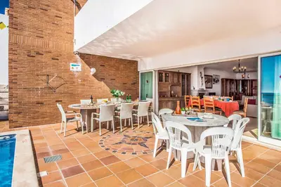 a dining room with tables and chairs and a pool at Villa Oceano in Albufeira