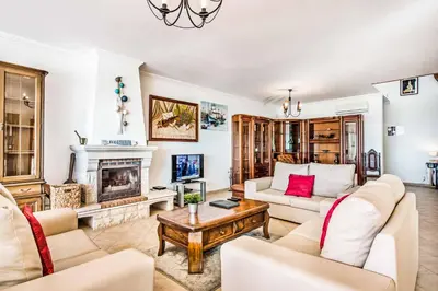 a living room with white furniture and a fireplace at Villa Oceano in Albufeira