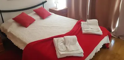 a bedroom with a bed with red and white sheets and pillows at Villa Oceano in Albufeira