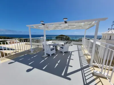 a white pergola on a deck with a table and chairs at Villa Oceano in Albufeira