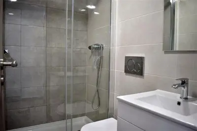 a bathroom with a shower and a toilet and a sink at Rua José Afonso in Albufeira