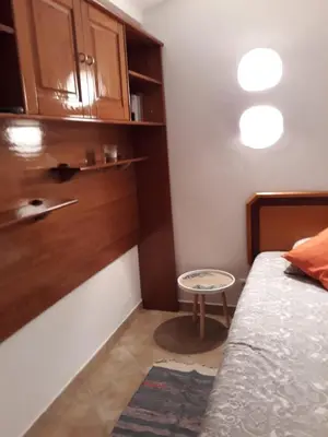 a small bedroom with a bed and a small stool at Casa Boneca - Aldeia das Açoteias in Albufeira