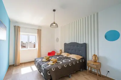 a bedroom with a blue bed and a window at Apartamentos Old Town by Umbral in Albufeira
