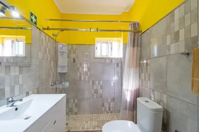 a bathroom with a white toilet and a yellow ceiling at Apartamentos Old Town by Umbral in Albufeira