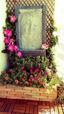 a statue of a face in a bunch of flowers at SunHouse Room in Albufeira