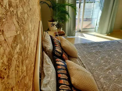 a bedroom with pillows on a bed with a wall at SunHouse Room in Albufeira