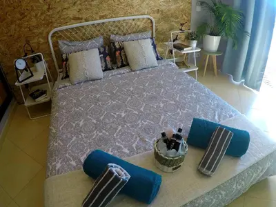 a bedroom with a bed with blue pillows at SunHouse Room in Albufeira