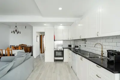 a kitchen with white cabinets and a couch in it at Casa Mina in Faro