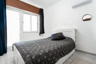 a bedroom with a bed with a black pillow on it at Casa Mina in Faro