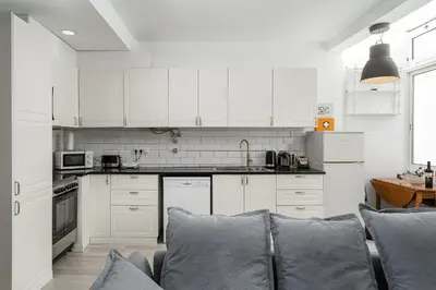 a kitchen with white cabinets and a couch at Casa Mina in Faro