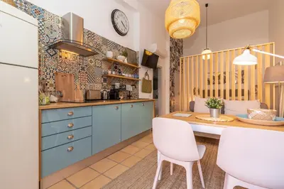 a kitchen with blue cabinets and a table and chairs at FARO DOWNTOWN STUDIOS in Faro