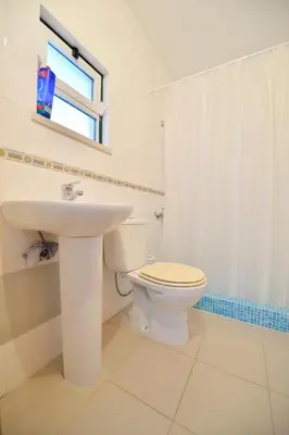 a white bathroom with a toilet and a sink at TownHouse next to Falésia Beach in Albufeira