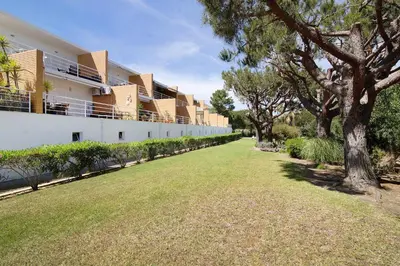an empty lawn in front of a building with trees at Yara Beach Apartments with Terrace in Albufeira