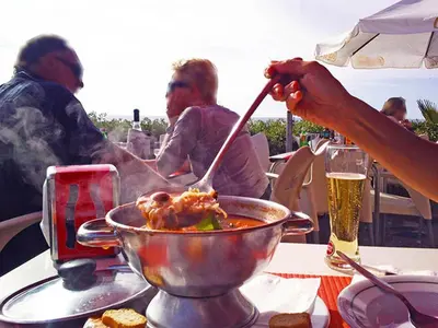 a person cooking food in a bowl on a table at Martin House - Montenegro - FARO - ALGARVE in Faro