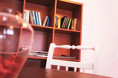 a chair sitting at a table in front of a book shelf at Martin House - Montenegro - FARO - ALGARVE in Faro