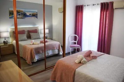 a bedroom with two beds and a mirror at Rising Sun Apartment in Albufeira