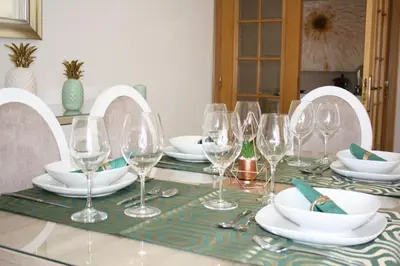a table with wine glasses and plates on it at Rising Sun Apartment in Albufeira