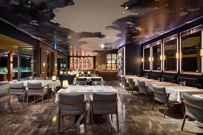 a dining room with tables and chairs and a wall of windows at EPIC SANA Algarve Hotel in Albufeira